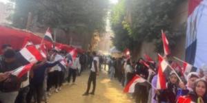 شباب أرض اللواء يرفعون علم مصر خلال مشاركتهم بانتخابات الرئاسة 2024